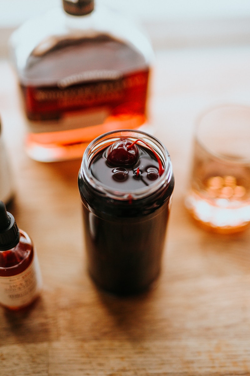 clear drinking glass beside black bottle